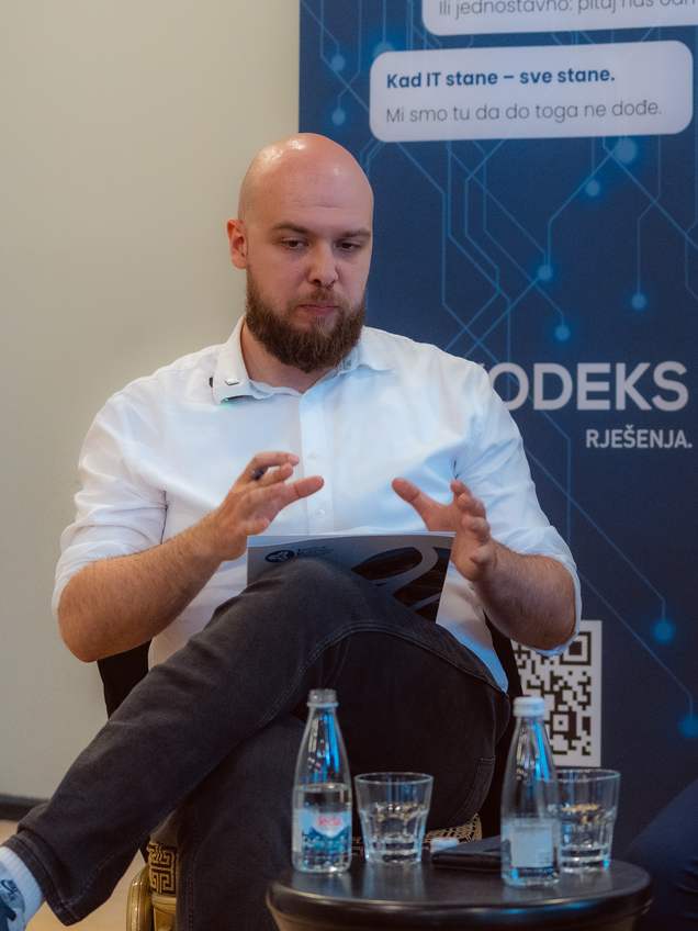 Tom Medek moderira razgovor na poslovnoj konferenciji