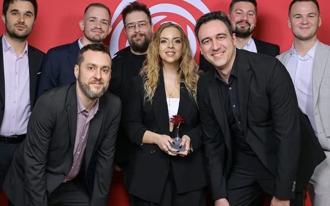Ekipa Tribine s kipićem Večernjakove ruže ispred crvene pozadine